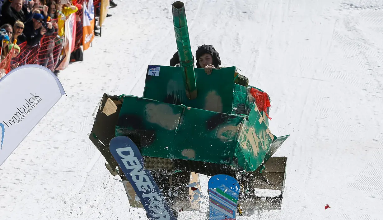 Peserta memakai kostum replika tank meluncur ke permukaan air selama kontes Jump Red Bull dan Freeze di ski resort Chimbulak, Kazakhstan (22/3). Dalam kontes ini para peserta mengundang tawa penonton yang menyaksikan. (REUTERS/Shamil Zhumatov)