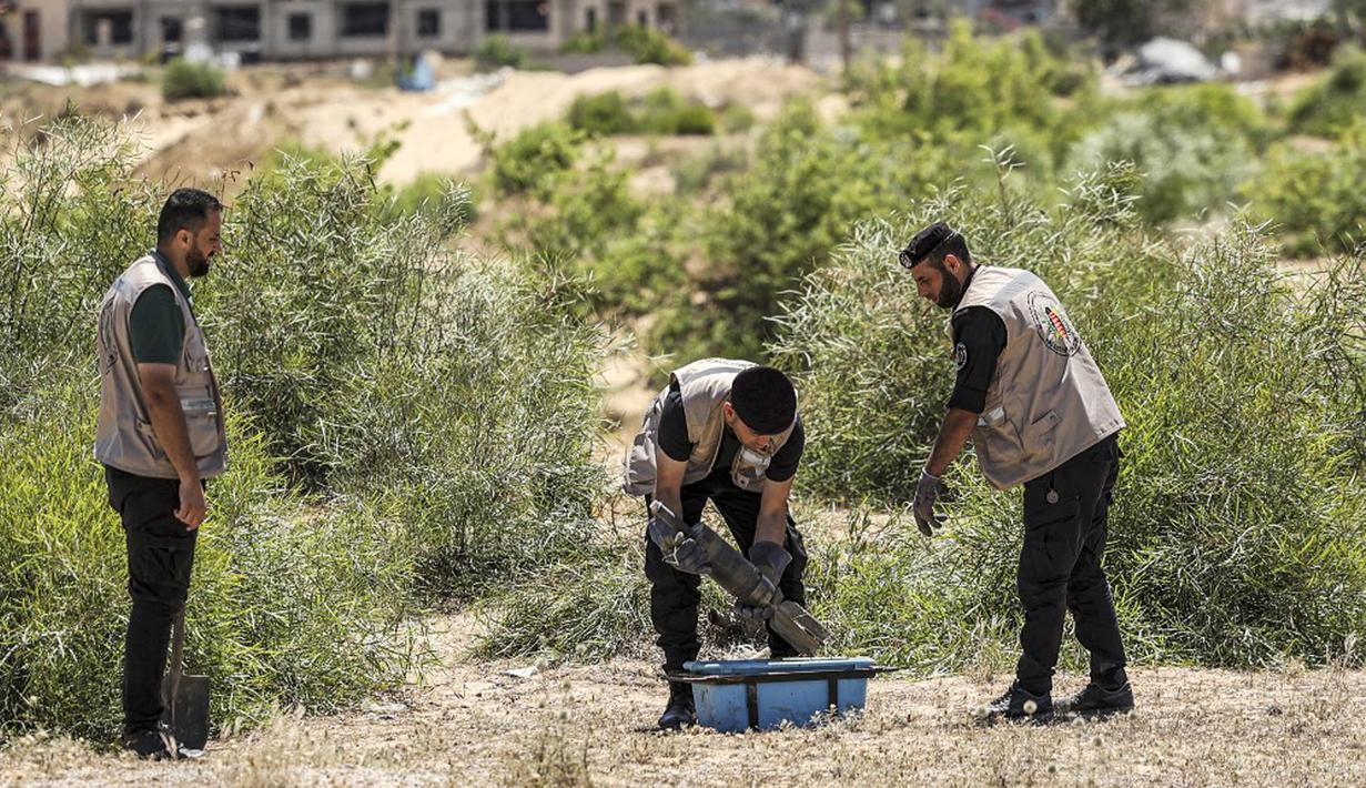 Pakar bahan peledak Hamas mengemas proyektil yang tidak meledak setelah konflik Mei 2021 dengan Israel di sebuah lapangan di Khan Yunis, Jalur Gaza, Sabtu (5/6/2021). Perang 11 hari antara Hamas dan Israel menewaskan 254 orang Palestina dan 12 orang Israel. (MAHMUD HAMS/AFP)