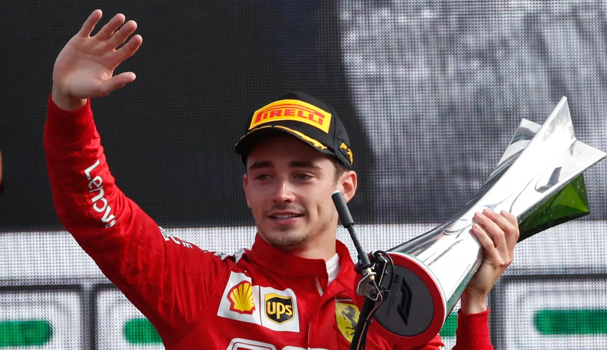Pembalap Ferrari Charles Leclerc memegang piala sambil melambaikan tangan usai memenangkan F1 GP Italia 2019 di Sirkuit Monza, Minggu (8/9/2019). Leclerc menjuarai F1 GP Italia 2019 setelah pertarungan alot melawan duo pembalap Mercedes, Lewis Hamilton dan Valtteri Bottas. (AP Photo/Antonio Calanni)