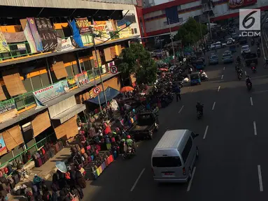 PKL dan parkir liar memadati trotoar serta bahu jalan di kawasan Pasar Senen, Jakarta, Kamis (7/2). Selain mengganggu pejalan kaki, kondisi tersebut juga menghambat arus lalu lintas. (Liputan6.com/Immanuel Antonius)
