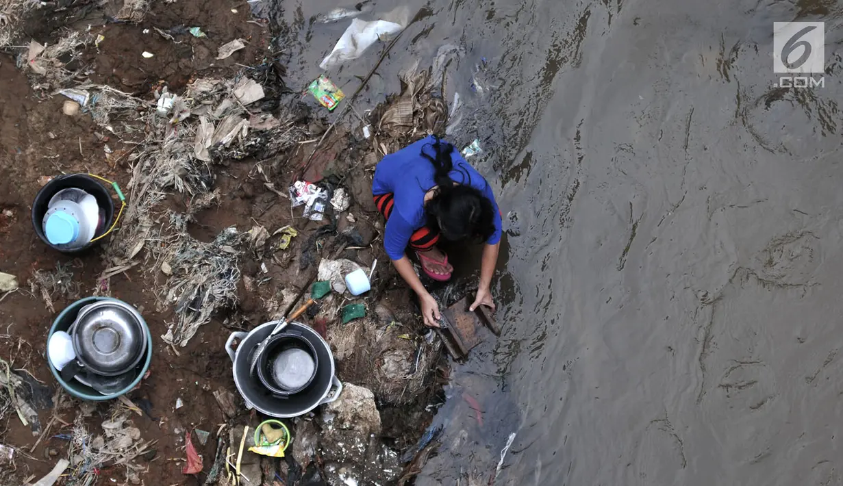 Aktivitas warga saat mencuci alat-alat masak di bantaran Kali Ciliwung, Bukit Duri, Jakarta, Kamis (12/4). Pemprov DKI berencana merelokasi bangunan liar yang berada di bantaran kali. (Merdeka.com/Iqbal Nugroho)