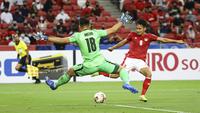 Kiper Singapura, Hassan Sunny, saat coba menghalau bola hasil tembakan winger Timnas Indonesia, Witan Sulaeman, pada laga leg kedua semifinal Piala AFF 2020 di National Stadium, Sabtu (25/12/2021) malam WIB. (AP Photo/Suhaimi Abdullah)