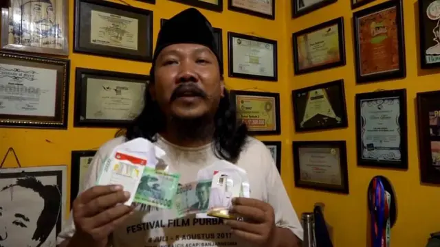 Bowo Leksono, pegiat sosial yang juga Direktur CLC Purbalingga menunjukkan amplop berisi uang dan semacam kartu pengenal seorang caleg DPR RI dari partai tertentu. (Foto: Liputan6.com/Bowo untuk Galoeh Widura)