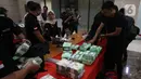 Petugas menata barang bukti saat rilis pengungkapan peredaran narkotika jenis sabu di Bareskrim Polri, Jakarta, Rabu (12/2/2020). Dirtidpid Narkoba Polri mengungkap sindikat narkotika jaringan Malaysia-Indonesia dengan barang bukti sabu 59 kg dan 20 butir pil ekstasi. (Liputan6.com/Angga Yuniar)