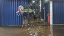 Genangan air berdampak langsung pada kegiatan jual beli. Jumlah pengunjung menurun karena akses yang sulit dan kondisi pasar yang kurang nyaman. Tampak dalam foto, aktivitas pedagang dan pembeli di Pasar Cipulir, Jakarta, Jumat (23/1/2026). (merdeka.com/Arie Basuki)