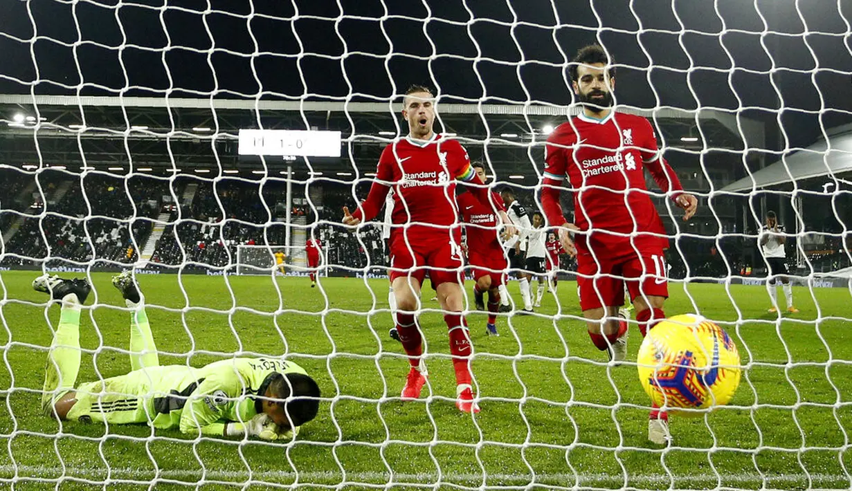 Pemain Liverpool Mohamed Salah (kanan) berlari untuk mengambil bola usai mencetak gol dari titik penalti ke gawang Fulham pada pertandingan Liga Premier Inggris di Stadion Craven Cottage, London, Minggu (13/12/2020). Liverpool dan Fulham bermain imbang 1-1. (AP photo/Matt Dunham, Pool)