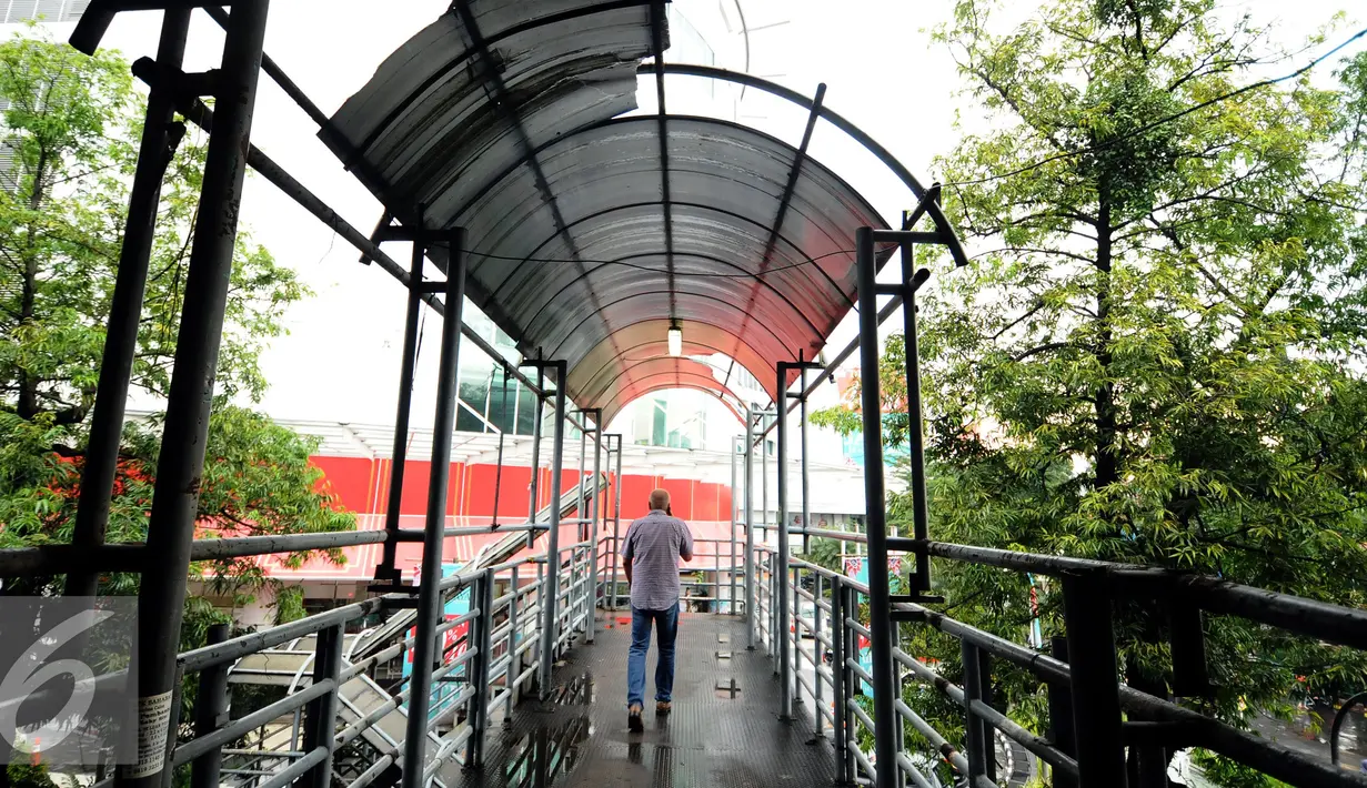 Pejalan kaki melintas di Jembatan Penyeberangan Orang (JPO) di Jalan Iskandarsyah, Jakarta, Selasa (1/11). Tampak JPO yang tidak terawat dengan kondisi atap yang lepas dan berlubang. (Liputan6.com/Helmi Fithriansyah)