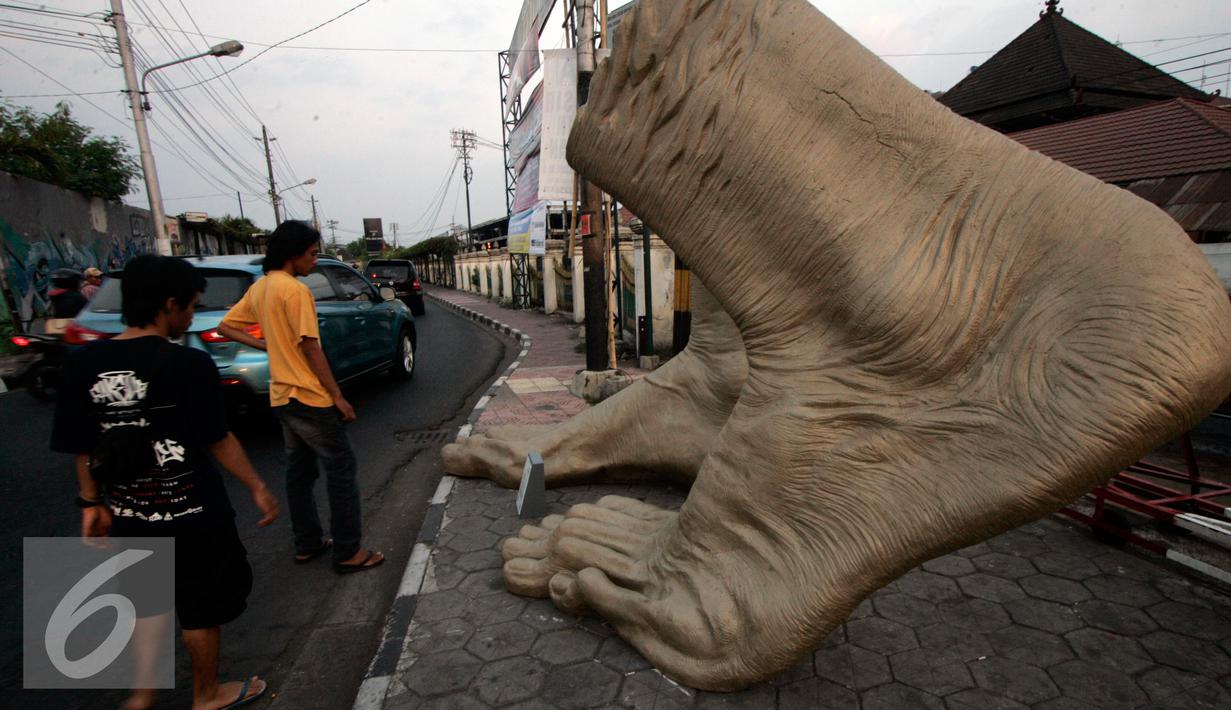 Sejumlah pengunjung menagami karya patung kaki pada Jogja Street Sculpture Project di Jalan Mangkubumi , (30/10/15). Sejumlah karya seni patung di paang di ruang publik yang di ikuti oleh 32 pematung. (Foto /Boy T Harjanto)
