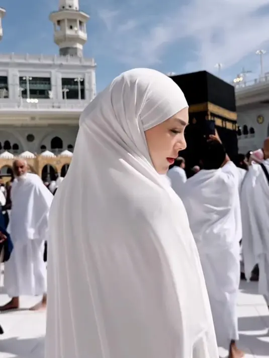 Dalam perjalanannya ke Tanah Suci, penampilannya tidak hanya anggun dalam balutan busana syar’i, tetapi juga memancarkan kecantikan natural yang semakin bersinar dengan riasan fresh dan effortless. [@celie_evangelista].