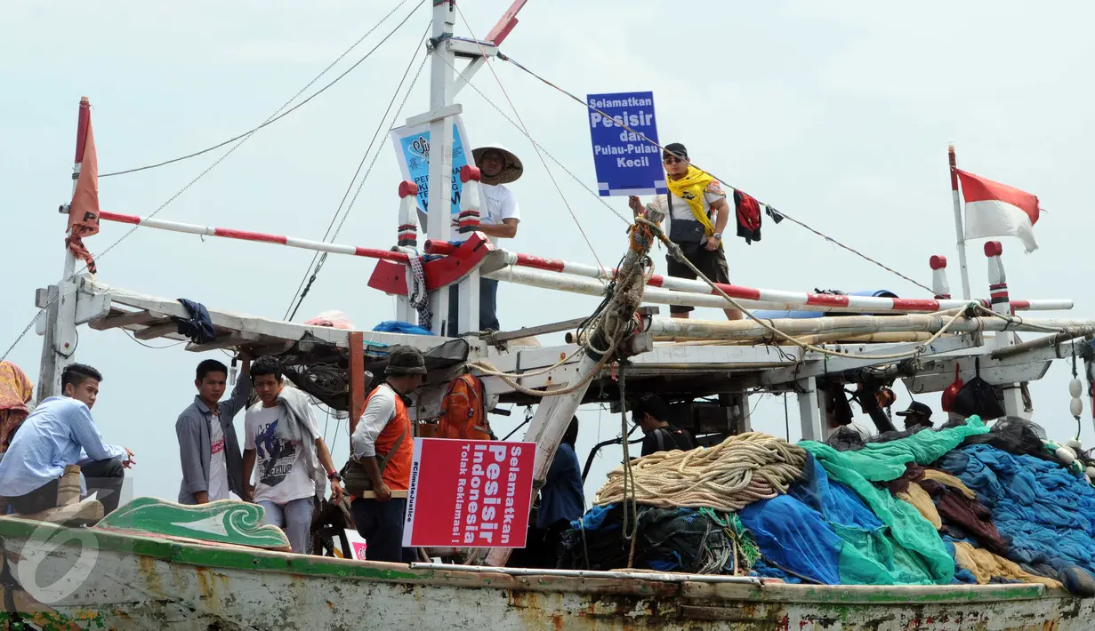 Sejumlah nelayan bersama aktivis Walhi menunjukkan poster berisi penolakan terhadap proyek reklamasi Teluk Jakarta saat upacara sedekah bumi yang lebih dikenal dengan sebutan Nadran di Muara Angke, Jakarta, Minggu (13/12/2015). (Liputan6.com/Helmi Afandi)