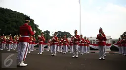Aksi marching band Paspampres memainkan alat musik trompet dan baritone horn di halaman luar Istana Merdeka, Jakarta, Minggu (28/8). Pergantian pasukan jaga Istana Kepresidenan menjadi objek atraksi wisata baru bagi warga. (Liputan6.com/Faizal Fanani)