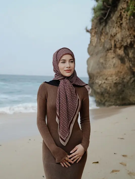 Padu padan knitted dress dan hijab segi empat bermotif sempurna untuk liburan di pantai. [@emyaghnia]