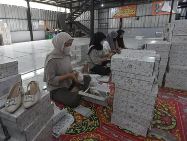 Pekerja melakukan pengepakan produk tas dan sepatu sandal yang akan dikirim ke pelanggan melalui marketplace di bengkel kerja Patris di kawasan Katulampa, Bogor, Jawa Barat, Senin (14/4/2025). (merdeka.com/Arie Basuki)