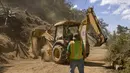 Pekerja membersihkan puing-puing dari jalan setelah gempa berkekuatan 6,2 skala Richter semalam, di dusun El Hato di Antigua, Guatemala, 16 Februari 2022. Gempa tersebut menyebabkan tanah longsor di jalan, kerusakan rumah dan pemadaman listrik. (AP Photo/ Santiago Billy)