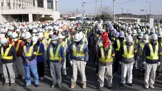 Sejumlah pekerja mengheningkan cipta untuk mengenang para korban bencana gempa dahsyat dan tsunami besar di Jepang pada 11 Maret 2011 silam, sebelum memulai pekerjaan mereka di Namie, Prefektur Fukushima, Jumat (11/3/2016). (REUTERS / Kyodo)