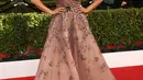 Taraji P. Henson menggunakan rancangan dari Reem Acra perpaduan dengan Nirav Modi Jewelry. Gaun transparan berwarna pink ini sukses membuat pesonanya semakin stunning dan sempurna. (Jordan Strauss/Invision/AP)