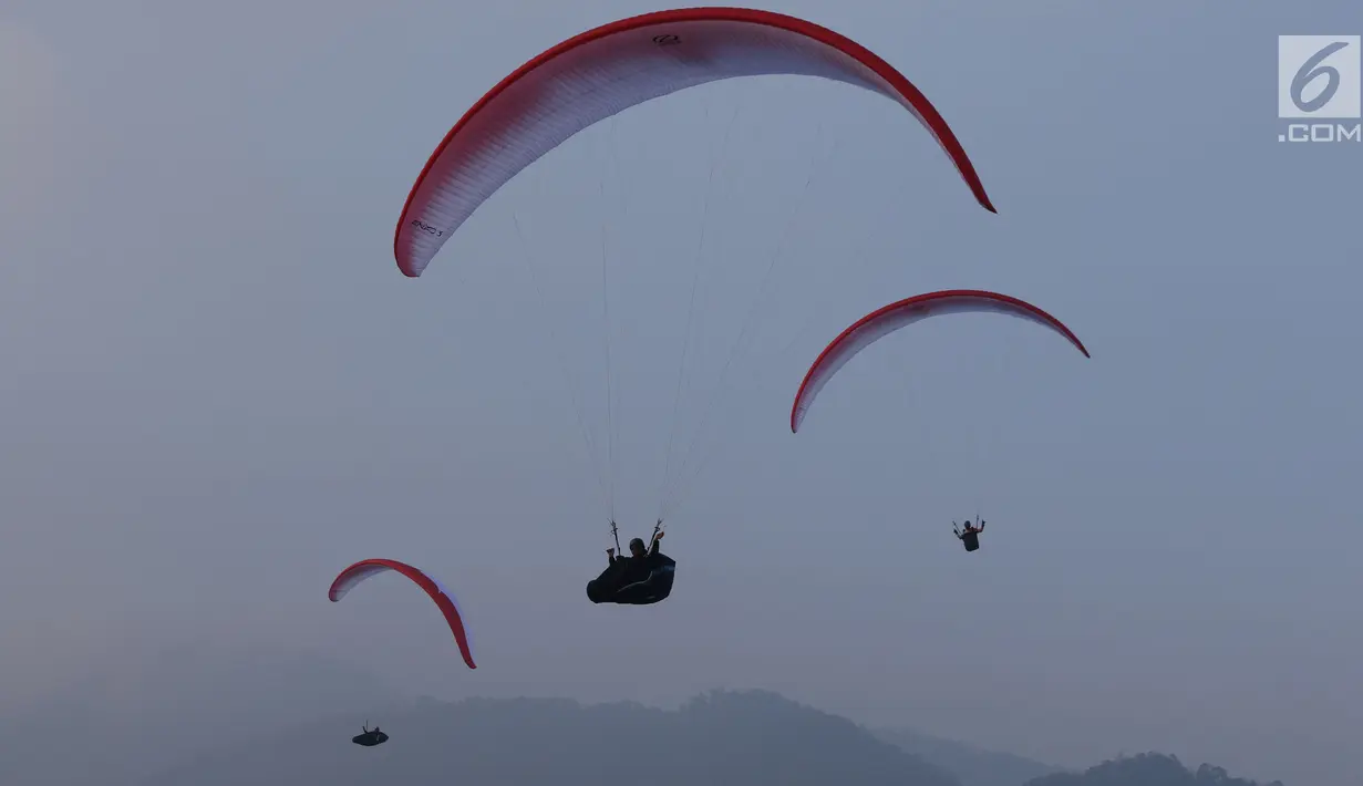 Tiga atlet Paralayang Indonesia berlatih terbang nomor Cross Country di kawasan Puncak, Cianjur, Jawa Barat, Kamis (26/7). Latihan ini mematangkan persiapan jelang laga Asian Games 2018, Agustus mendatang. (Liputan6.com/Helmi Fithriansyah)