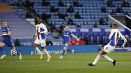 Striker Crystal Palace, Wilfried Zaha (kanan) melepaskan tendangan yang berbuah gol ke gawang Leicester City dalam laga lanjutan Liga Inggris 2020/2021 pekan ke-33 di King Power Stadium, Leicester, Senin (26/4/2021). Leicester menang 2-1 atas Crystal Palace. (AP/Andrew Boyers/Pool)