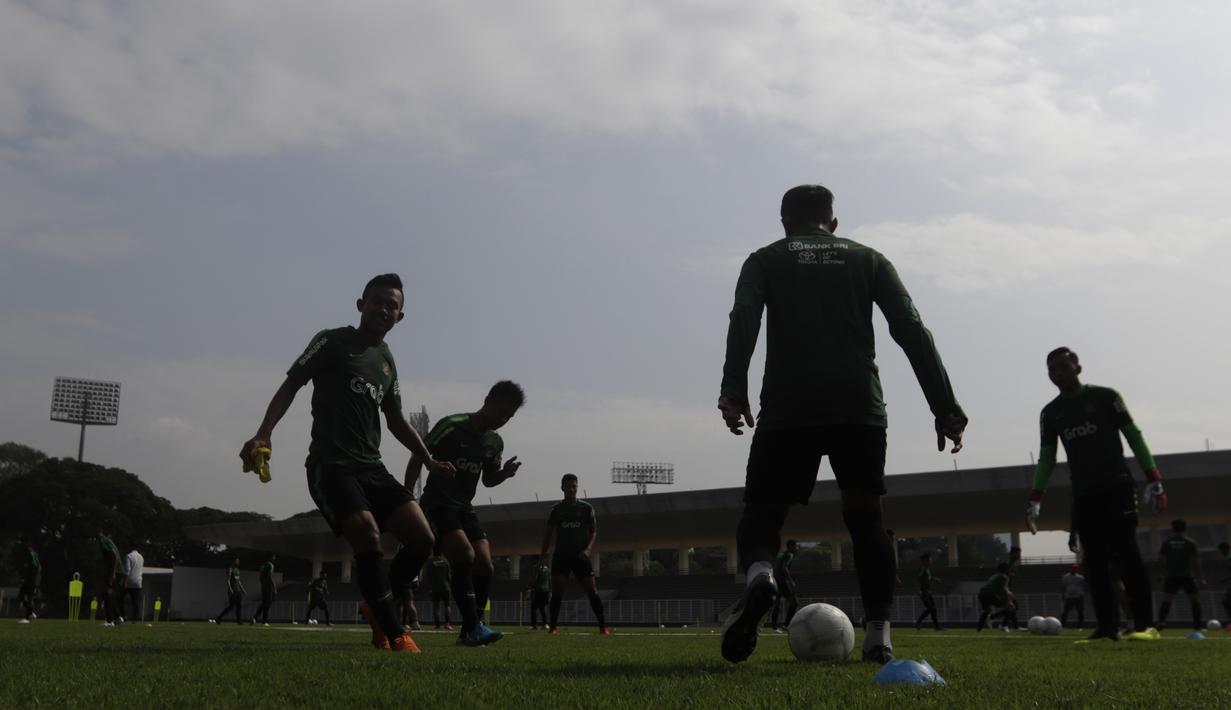 Siluet para pemain Timnas Indonesia U-22 saat latihan di Stadion Madya, Jakarta, Selasa (8/1). Latihan ini merupakan persiapan jelang Piala AFF U-22. (Bola.com/Vitalis Yogi Trisna)