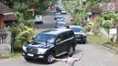 Seorang polisi mengatur lalu lintas iring-iringan mobil rombongan mantan Presiden Amerika Serikat Barack Obama melintas di kawasan Bongkasa, Badung, Bali, Senin (26/6). (Liputan6.com/Immanuel Antonius)