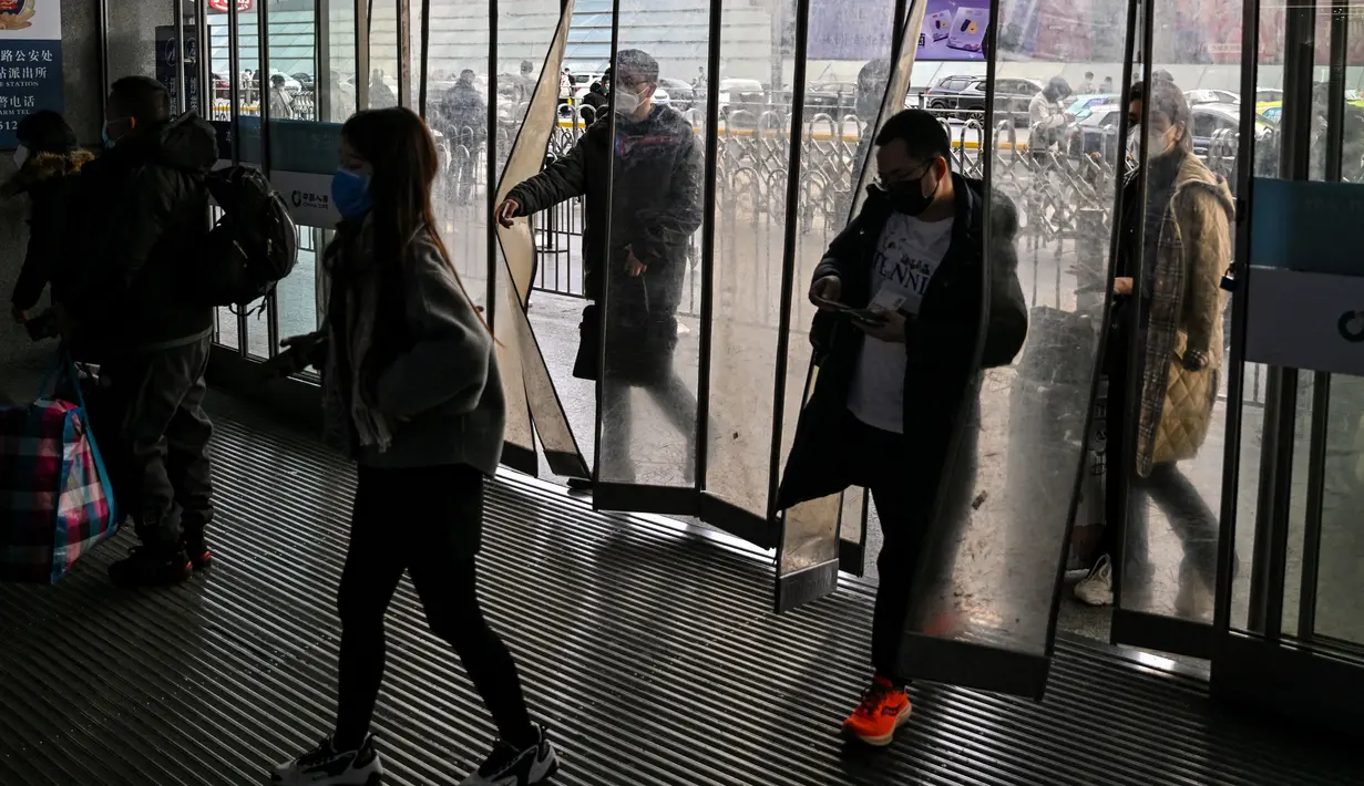 Calon penumpang tiba di Stasiun Hongqiao, Shanghai China, 11 Januari 2023. Migrasi tahunan di China dimulai dengan orang-orang kembali ke kampung halaman mereka untuk merayakan Tahun Baru Imlek. (Hector RETAMAL/AFP)