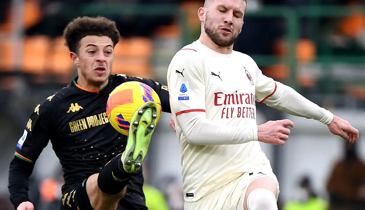 Penyerang AC Milan, Ante Rebic (kanan) berebut bola dengan bek Venezia, Ethan Ampadu pada pertandingan lanjutan Liga Serie A Italia di stadion Penzo, Venesia, Italia, Minggu (9/1/2022). Kemenangan ini membawa AC Milan menguasai puncak klasemen Serie A. (AFP/Marco Bertorello)