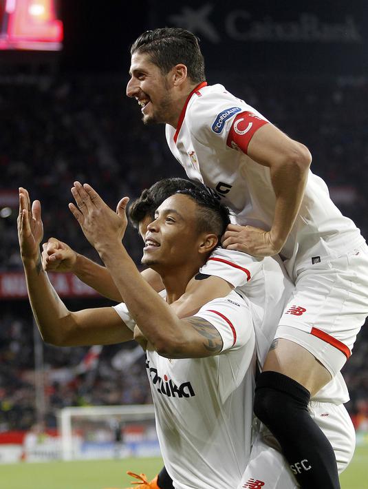Ekspresi para pemain Sevilla merayakan gol Luis Muriel (bawah) saat melawan Barcelona pada laga La Liga Santander di Sanchez Pizjuan stadium, (31/3/2018). Barcelona bermain imbang 2-2 dengan Sevilla. (AP/Miguel Morenatti)