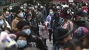 Warga berkumpul di kompleks perumahan untuk mendapatkan tes COVID-19 di Wuhan di provinsi Hubei China tengah, Selasa (22/2/2022). Wuhan, wabah besar pertama dari pandemi virus corona melaporkan lebih dari selusin kasus virus corona baru minggu ini. (Chinatopix via AP)