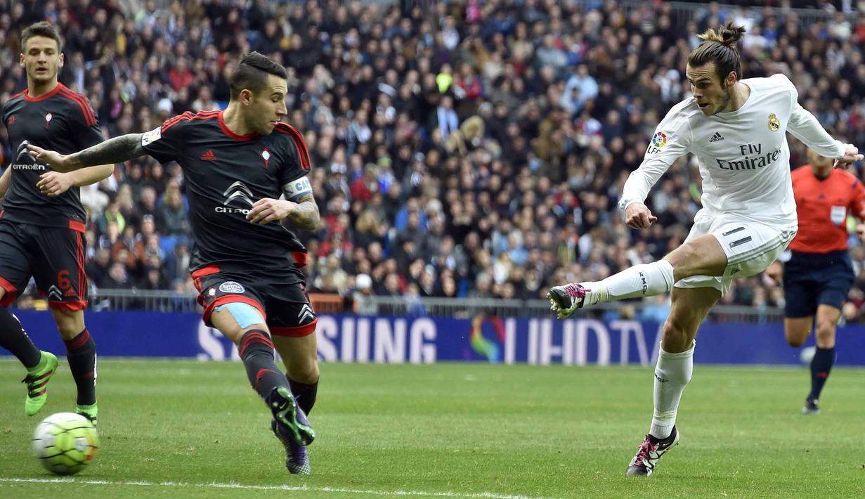 Pemain Real Madrid, Gareth Bale melakukan tembakan ke arah gawang Celta de Vigo saat dihadang para pemain lawan pada lanjutan La Liga Spanyol di Stadion Santiago Bernabeu , Madrid, Sabtu (5/3/2016). (AFP/Gerard Julien)
