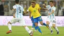 Striker Brasil, Neymar, berusaha melewati pemain Argentina pada laga persahabatan di Stadion King Abdullah, Jeddah, Selasa (16/10/2018). Brasil menang 1-0 atas Argentina. (AFP/STR)