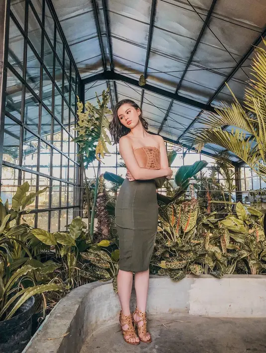 Gaya simpel Fabienne Nicole kenakan atasan bersiluet kemben dari kulit dengan detail tali di bagian tengah, dipadunya dengan midi skirt hijau army, dan heels tali. [Foto: Instagram/fabienne_fng]