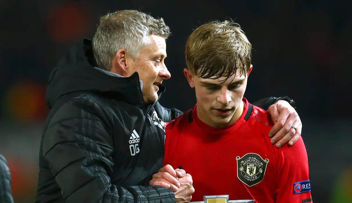 Manajer Manchester United Ole Gunnar Solskjaer (kiri) merangkul pemain Manchester United Brandon Williams usai menghadapi AZ Alkmaar pada pertandingan Grup L Liga Europa di Old Trafford, Manchester, Inggris, Kamis (12/12/2019). Manchester United menang 4-0. (AP Photo/Dave Thompson)