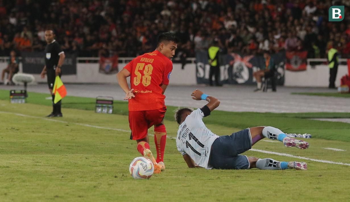 Pemain Persita Tangerang, Muhammad Toha, terjatuh saat berebut bola dengan pemain Persija Jakarta, Rayhan Hannan pada laga pekan ke-21 BRI Liga 1 di Stadion Utama Gelora Bung Karno (SUGBK), Jakarta Pusat, Minggu (3/12/2023). (Bola.com/M Iqbal Ichsan)