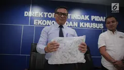 Dir Tipideksus Bareskrim Brigjen Agung Setya (kiri) menunjukkan kemasan gula rafinasi di Gedung Bareskrim, Jakarta, Rabu (1/11). Menurut pihak kepolisian, gula rafinasi tidak layak langsung dikonsumsi dan harus diolah lagi. (Liputan6.com/Faizal Fanani)