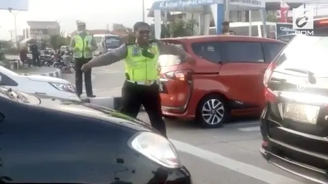 Di tengah kemacetan saat liburan panjang, seorang polisi menghibur diri dan pengendara dengan berjoget saat mendengar lagu Via Vallen.