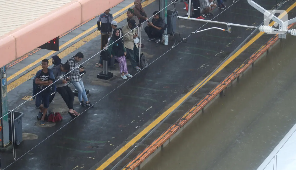Calon penumpang menunggu di Stasiun kereta Tanah Abang, Jakarta, Rabu (1/1/2020). Hujan yang mengguyur Jakarta sejak Selasa sore (31/12/2019) mengakibatkan rel terendam dan perjalanan kereta dari dan ke Stasiun Tanah Abang dihentikan sementara. (Liputan6.com/Helmi Fithriansyah)