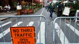 Sebuah gerbang menutup restoran yang mengoperasikan area luar ruangan (outdoor) hingga ke trotoar dan jalanan di New York pada 3 Oktober 2020. Kota tersebut mengizinkan restoran membuat area makan outdoor sebagai upaya mengatasi dampak ekonomi COVID-19 yang berkelanjutan. (AP Photo/John Minchillo)