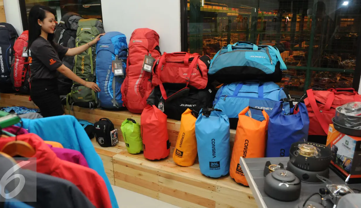 Seorang karyawati memamerkan beberapa produk Consina mulai dari tas hingga peralatan outdoor lainnya di gudang pusat Consina yang baru saja diresmikan di Naragong, Bekasi, Senin (12/12). (Liputan6.com/Helmi Affandi)
