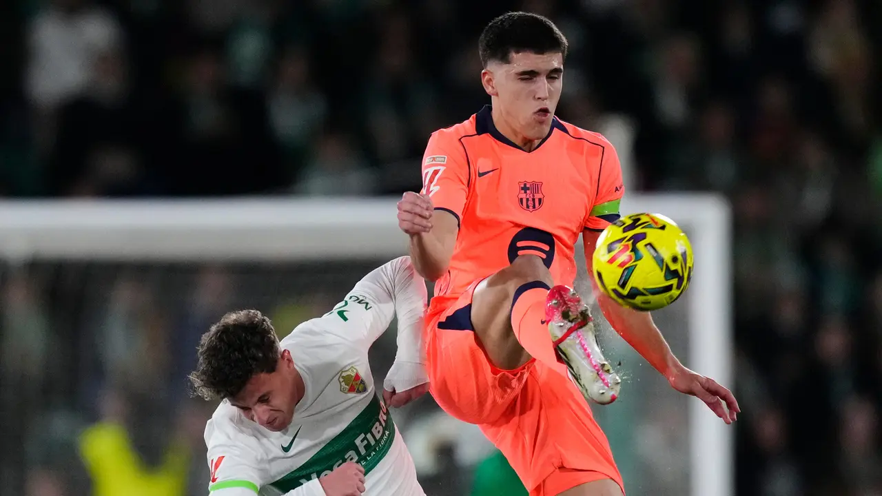 Pemain Barcelona Pau Cubarsi (kanan) berebut bola dengan pemain Elche German Valera
