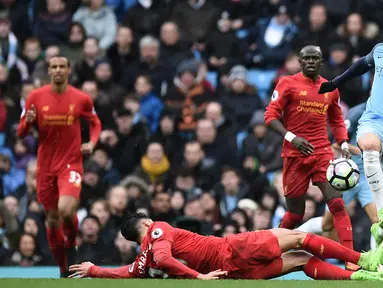 Gelandang Manchester City, Leroy Sane, berusaha melewati hadangan gelandang Liverpool, Emre Can, pada laga Liga Inggris di Stadion Ettihad, Inggris, Minggu (19/3/2017). Kedua klub bermain imbang 1-1. (AFP/Oli Scarff)