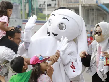 Sejumlah anak didampingi orang tuanya ttampak antusias menyapa maskot Piala Dunia 2022, La'eeb, saat Car Free Day (CFD) di kawasan Sudirman, Jakarta, Minggu (06/11/2022). (Bola.com/M iqbal Ichsan)