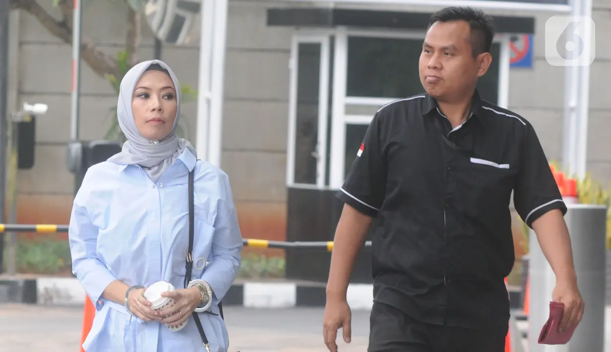 Terpidana General Manager Commercial PT Humpuss Transportasi Kimia, Asty Winasti dikawal petugas berjalan masuk akan menjalani pemeriksaan sebagai saksi di Gedung KPK, Jakarta, Selasa (12/11/2019). (merdeka.com/Dwi Narwoko)
