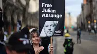 Seorang demonstran memegang plakat bergambar pendiri WikiLeaks, Julian Assange dalam sebuah protes di luar Royal Courts of Justice, Pengadilan Tinggi Inggris, di pusat kota London, pada tanggal 20 Februari 2024. (Daniel LEAL/AFP)