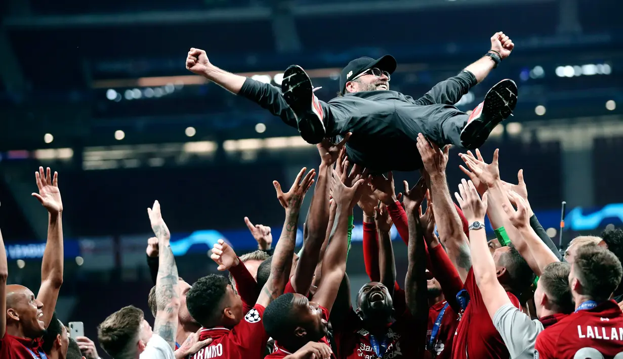 Pelatih Liverpool Juergen Klopp dilemparkan ke udara oleh anak asuhnya saat merayakan gelar juara Liga Champions usai mengalahkan Tottenham Hotspur di Stadion Wanda Metropolitano, Madrid, Spanyol, Sabtu (1/6/ 2019). (AP Photo/Francisco Seco)