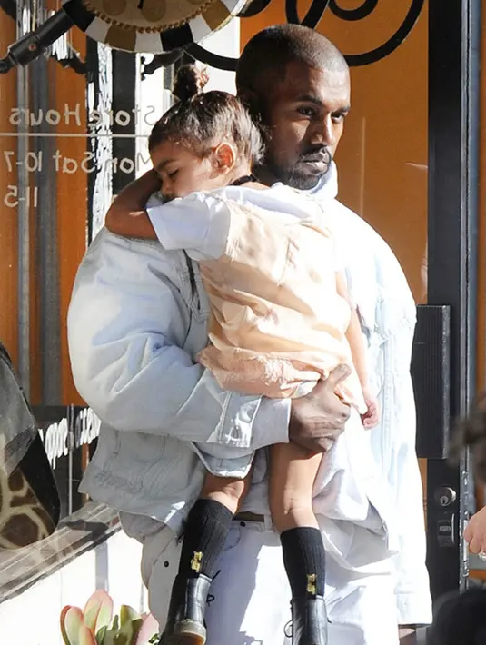 Kanye West menggendong anak pertamanya, North West, saat tengah terlelap. (REX/Shutterstock/HollywoodLife)