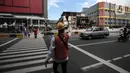 Petugas mengatur lalu lintas untuk warga menyeberang jalan menggunakan pelican crossing di kawasan Glodok, Jakarta, Sabtu (22/1/2022). PT Transportasi mulai mengoperasikan Halte Glodok baru dengan rute Blok M - Kota (Koridor 1). (Liputan6.com/Johan Tallo)