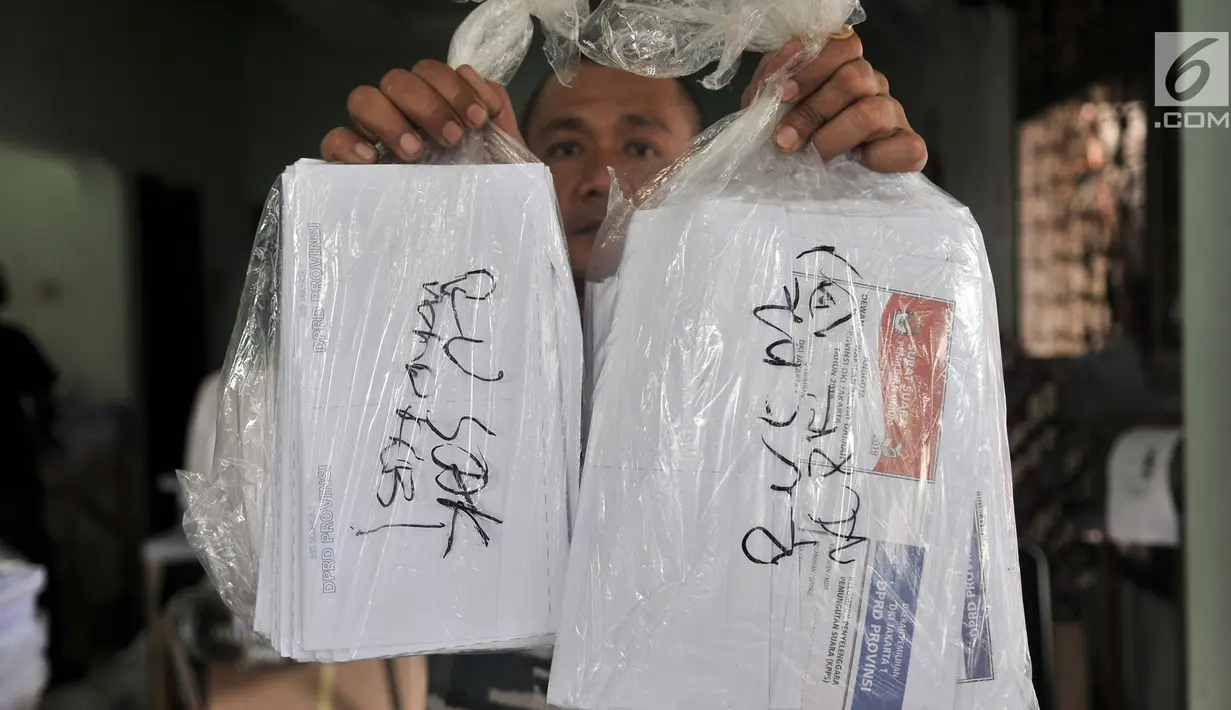 Petugas menunjukkan rusak yang telah dipisahkan di Gedung Logistik KPU Kota Jakarta Pusat, Jakarta, Selasa (5/3). Sebanyak 60 persen surat suara rusak akibat terpotong atau tidak simetris dan bercak noda. (merdeka.com/Iqbal Nugroho)