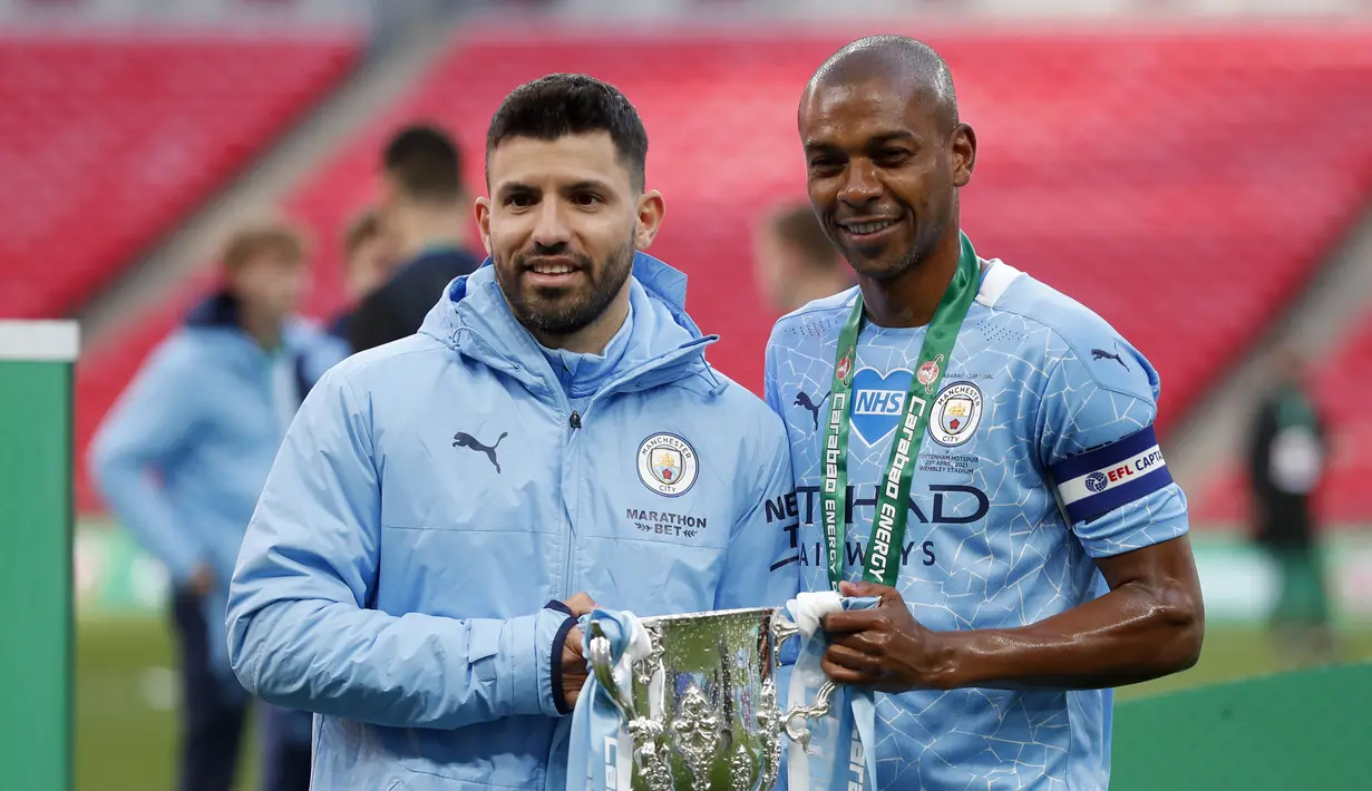 Pemain Manchester City , Sergio Aguero dan Fernandinho berpose dengan trofi saat merayakan kemenangan atas Tottenham Hotspur pada pertandingan final Piala Liga Inggris di stadion Wembley di London, Senin (26/4/2021). (AP Photo/Alastair Grant)