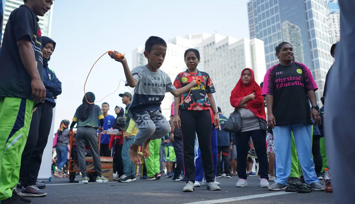 Seorang anak mencoba olahraga lompat tali atau jumping rope bersama komunitas penggerak olahraga di tengah kegiatan Car Free Day kawasan Bundaran Hotel Indonesia, Minggu (30/6/2019). Kegiatan tersebut mengajak masyarakat untuk hidup sehat dengan berolahraga. (Liputan6.com/Immanuel Antonius)