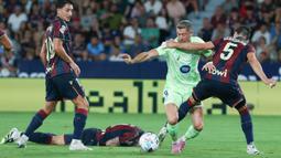 Pemain Barcelona, Robert Lewandowski, berusaha melewati pemain Levante pada jornada kedua La Liga 2025/2026 di Estadio Ciudad de Valencia, Minggu (24/8/2025) dini hari WIB. (AP Photo/Alberto Saiz)